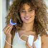 Donna con il set per lo sbiancamento dentale Phone PAP+ di Diamond Smile