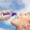 Donna con in mano la schiuma sbiancante viola Diamond Smile per la correzione del colore dei denti