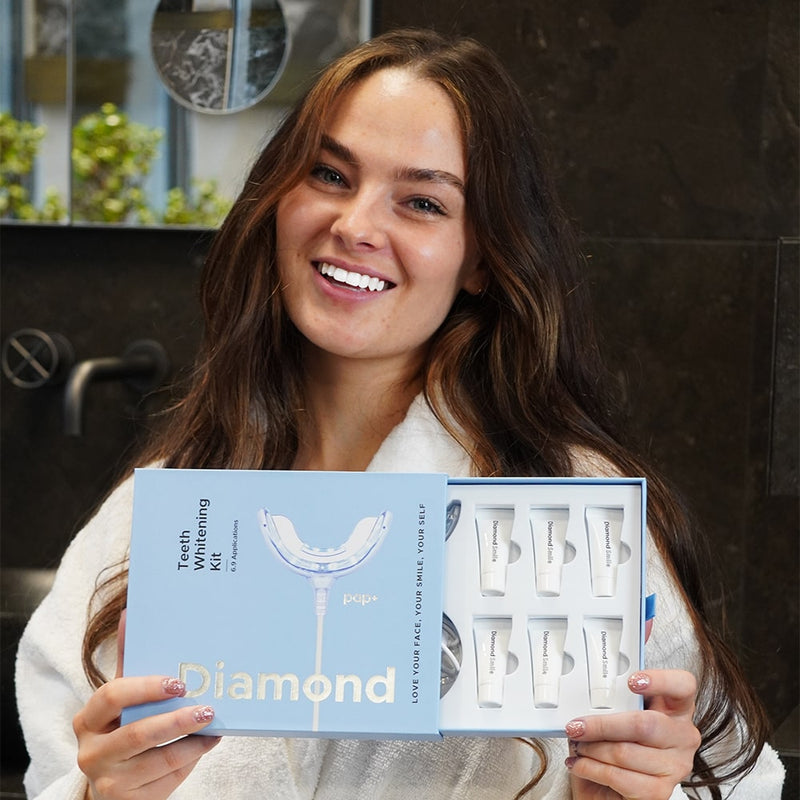 Una donna con il set di sbiancamento dentale Phone PAP+ di Diamond Smile