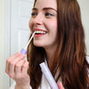 Donna in bagno con in mano lo stick sbiancante Diamond Smile