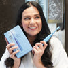 Donna con lo spazzolino sonico Power LED Bleaching di Diamond Smile in mano in bagno