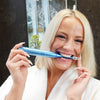 Donna con lo spazzolino sonico sbiancante Power LED di Diamond Smile in bocca in bagno