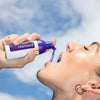 Donna con in mano la schiuma sbiancante viola Diamond Smile per la correzione del colore dei denti